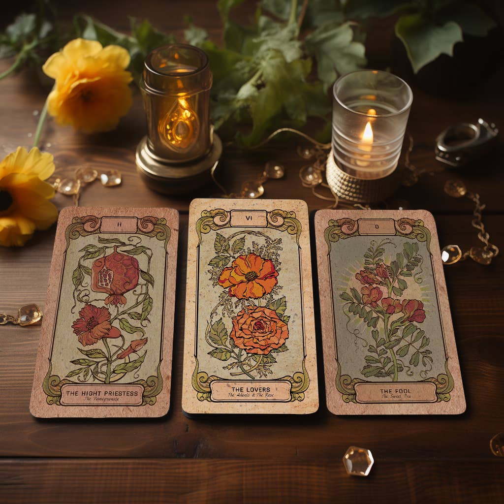 Botanica Oculta tarot deck card photographed beside a cup and flowers