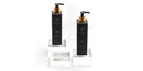 Keratin Shampoo and Mask bottles displayed on white tiered pedestals